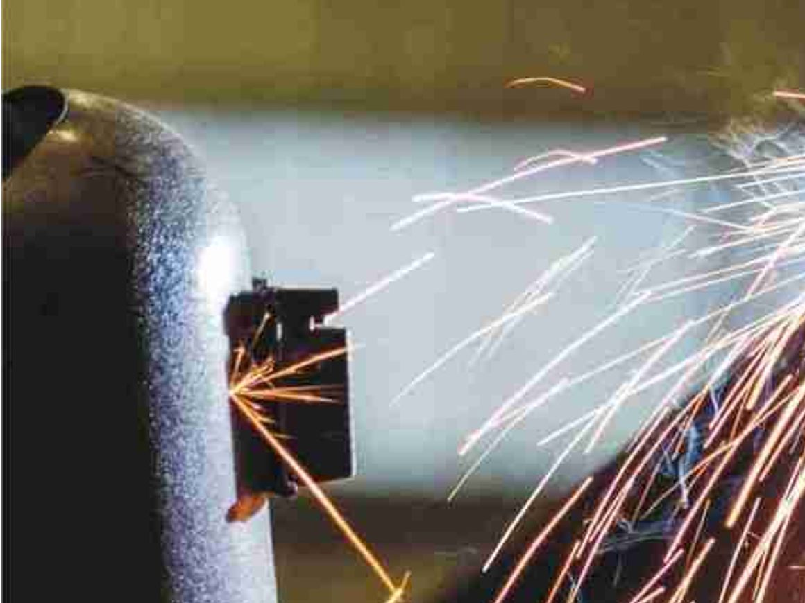 A welder in a protective mask working amid sparks